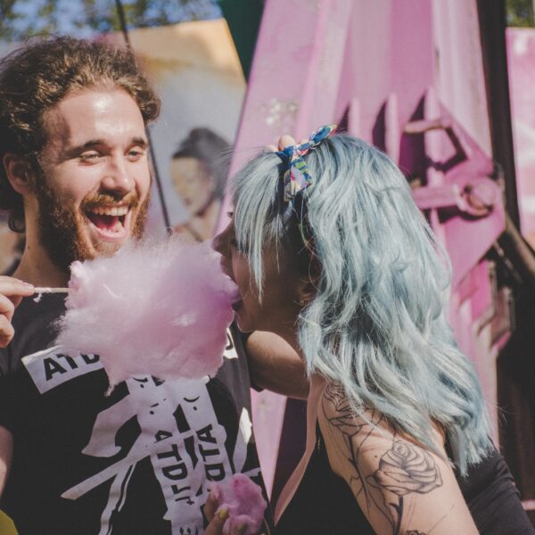 man and woman laughing while eating cotton candy